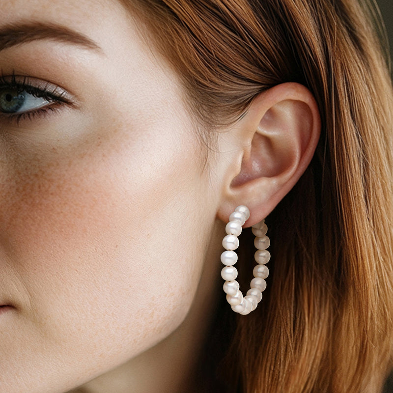 Cultured pearl hoop earrings with round pearls, 14kt yellow gold hoops on model