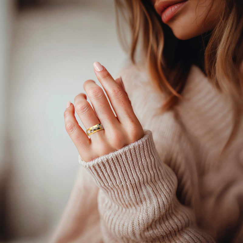 Gold moon-and-star diamond ring on a woman's finger, close-up