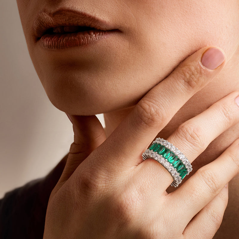 Sterling silver ring on hand with green emerald-cut center stones and clear side CZs