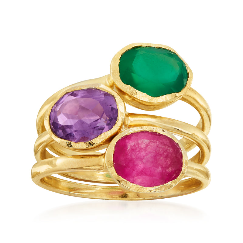 Three gold-tone rings with green, purple, and pink oval gemstones