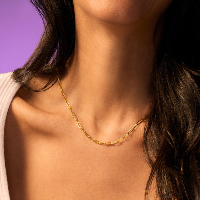 Yellow gold paper clip link necklace on collarbone, oval chain links