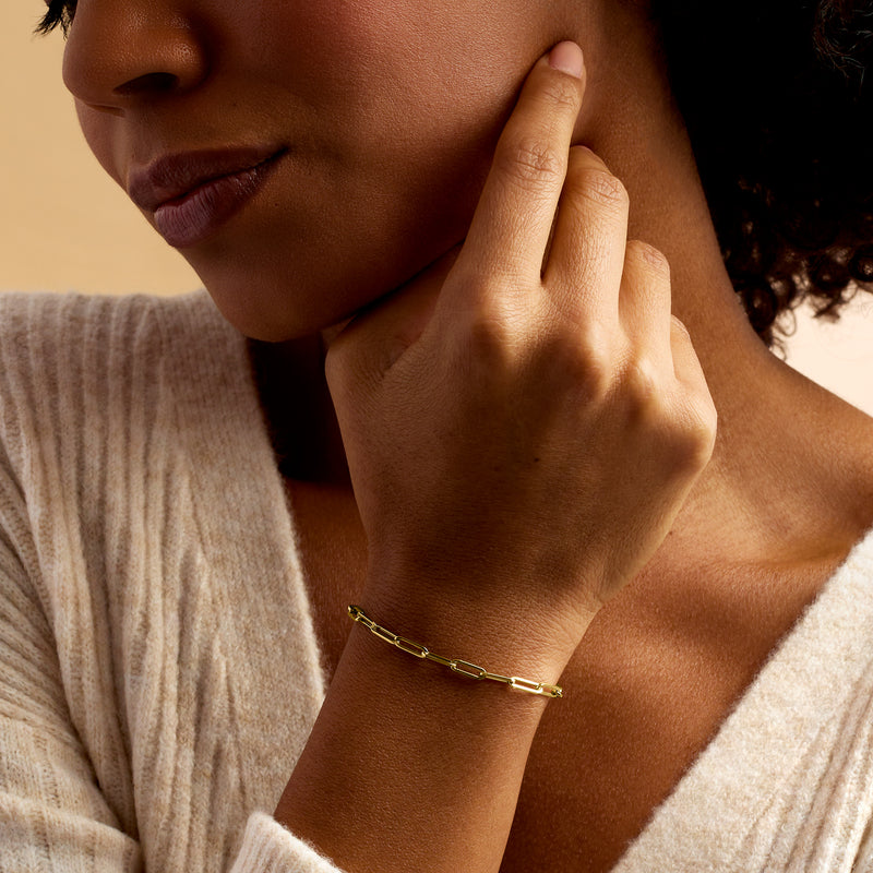 14kt yellow gold paper clip link bracelet on wrist, small polished chain links