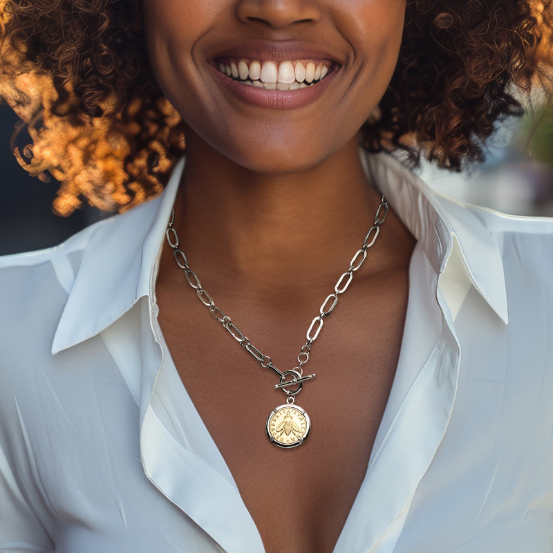 Sterling silver coin pendant necklace with gold lira medallion, centered on chest