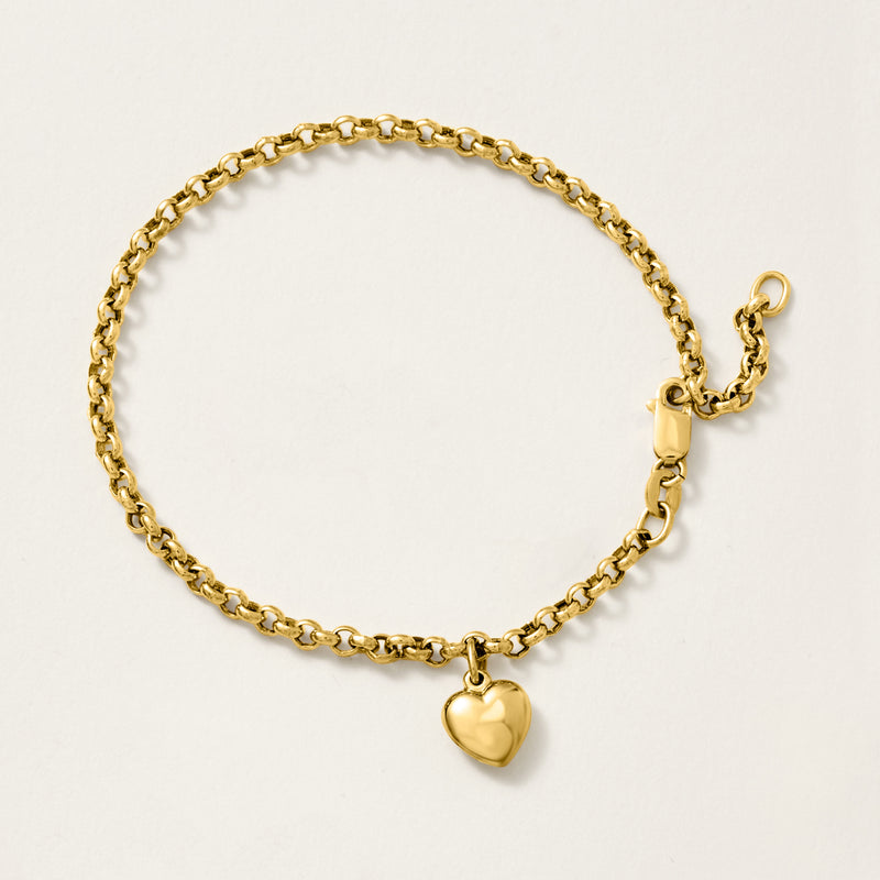 Yellow gold heart charm bracelet with curb chain and heart pendant near clasp