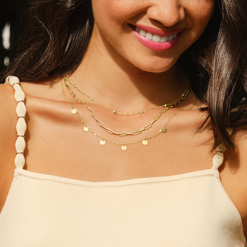 14kt yellow gold multi-circle necklace worn close to neckline with round disc charms
