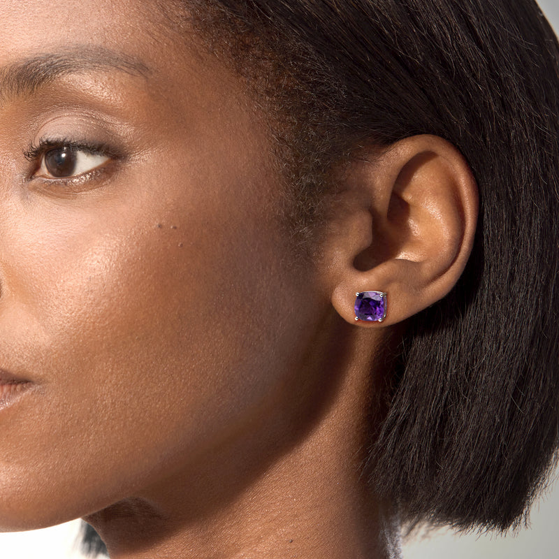 Amethyst stud earrings in sterling silver with purple cushion-cut gemstone on ear