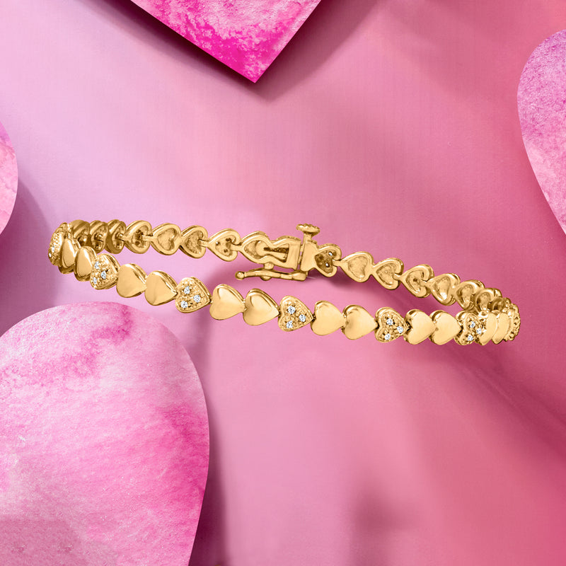 Gold heart bracelet with round stones and hinged clasp, angled view