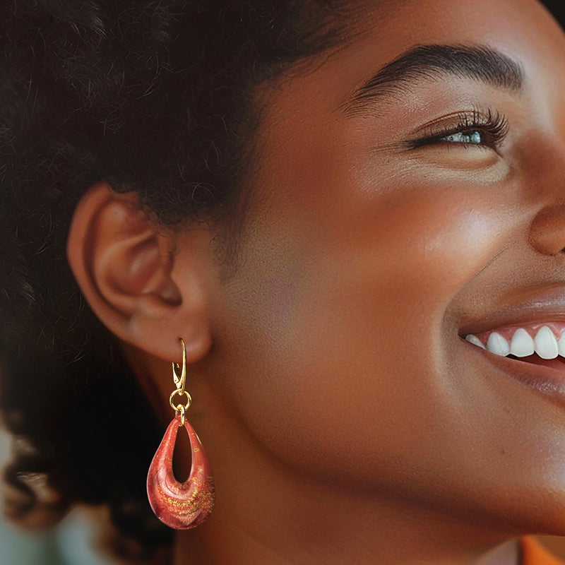 Teardrop glass drop earrings on gold leverback worn by model, red speckled swirl