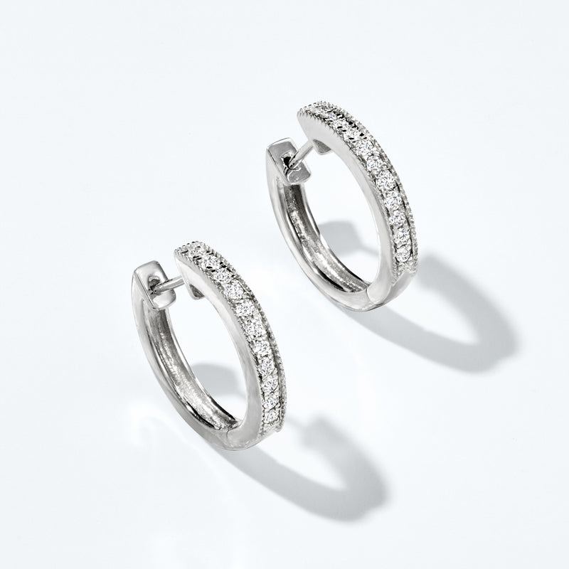 Sterling silver diamond hoop earrings with textured milgrain outside and hinged clasp.