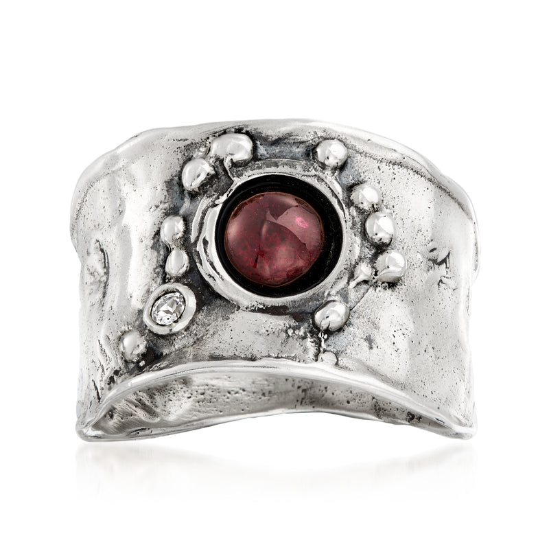 Sterling silver ring with round garnet center and small white accents around the bezel