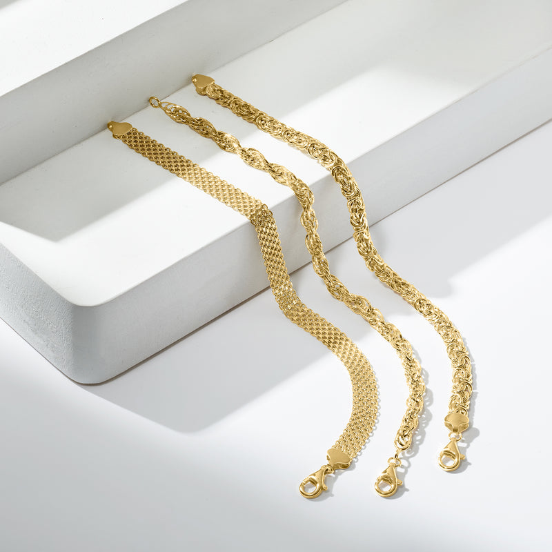 Three gold-tone link bracelets set, shown laid out with lobster clasps