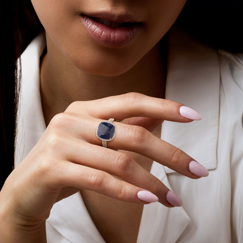 14kt yellow gold sapphire ring with diamond halo worn on hand, close-up