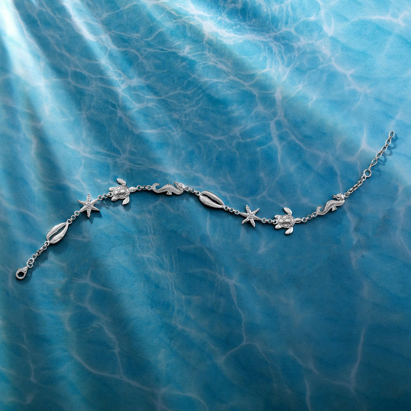 Sterling silver sea life anklet with starfish, seashell, and wave motif links