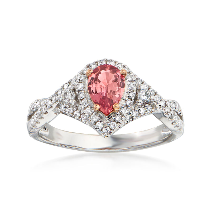 Two-tone gold ring with oval pink sapphire center, diamond halo and side clusters.