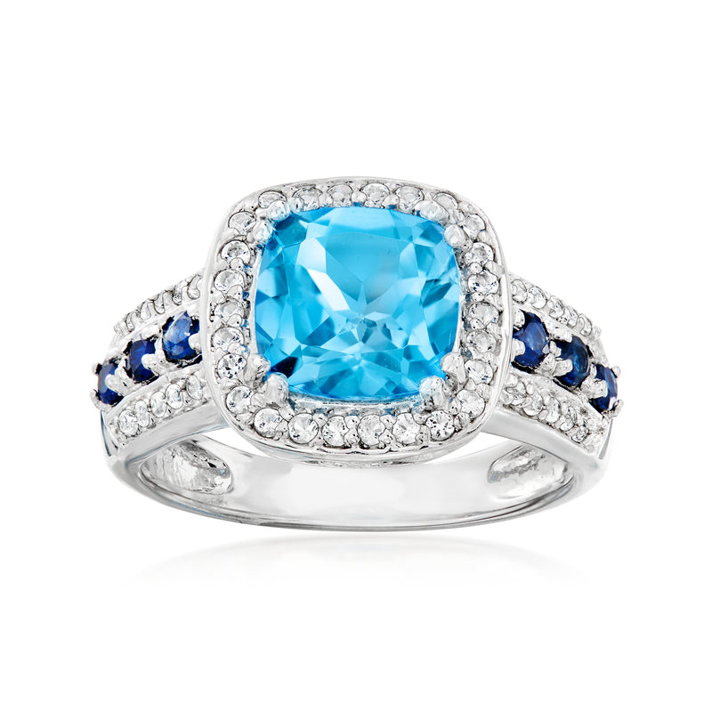 Sterling silver multi-gemstone ring with large oval blue center, clear halo, and sapphire sides
