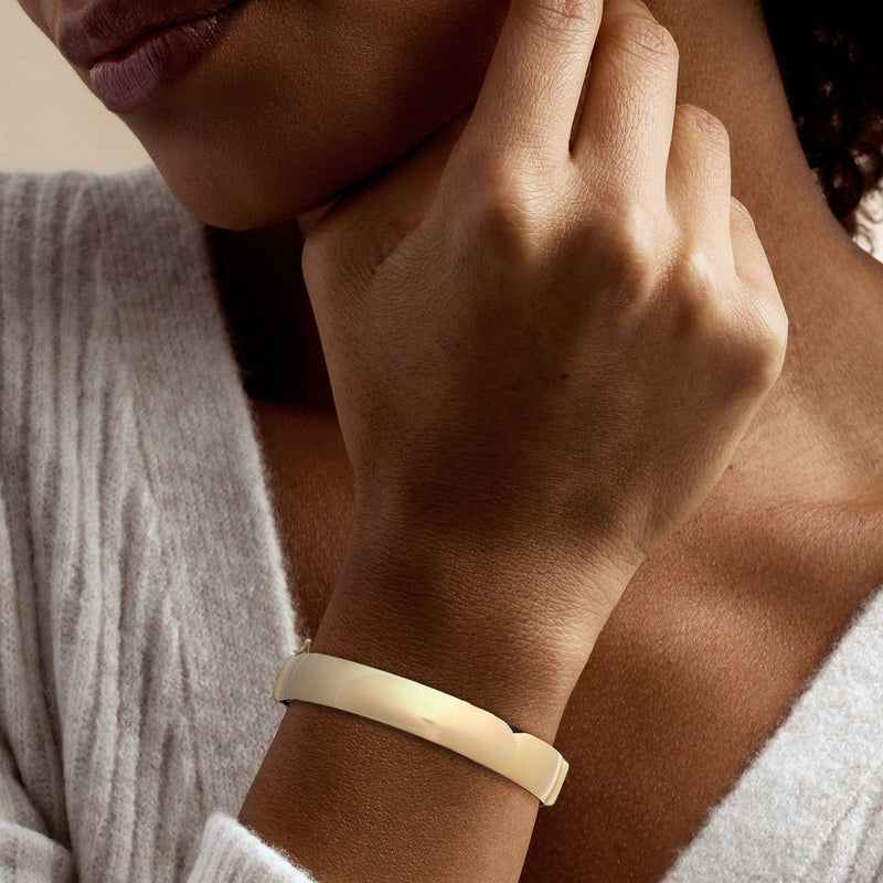 14kt yellow gold bangle bracelet on wrist, smooth hinged band