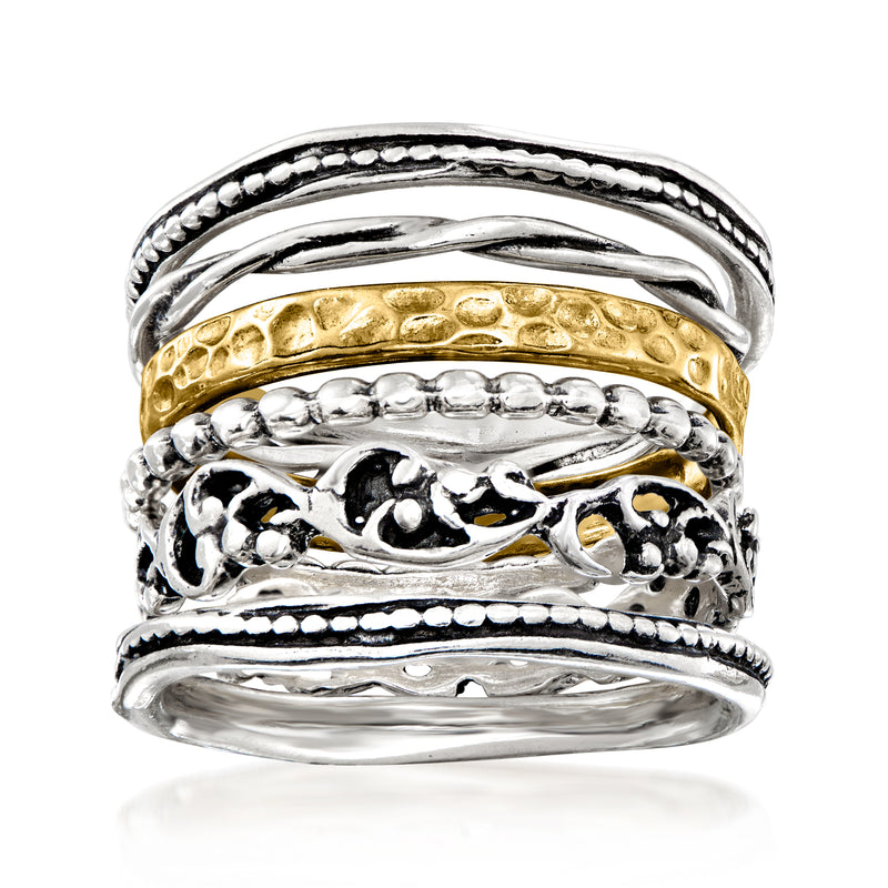 Stacked textured sterling silver rings with gold accent bands, ornate scroll design