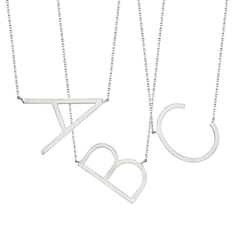 Sterling silver initial necklace set with several sideways letter pendants on chains