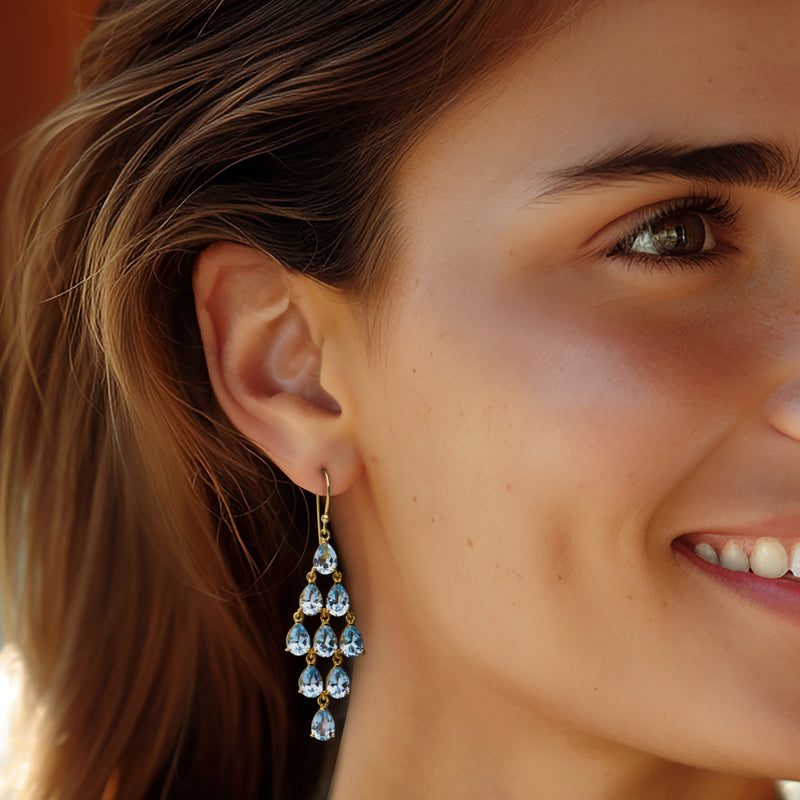 Sky blue teardrop stone chandelier earrings on gold earwire, worn