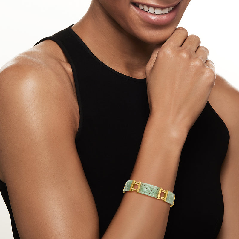 Jade green and gold bracelet worn on wrist with hinged clasp