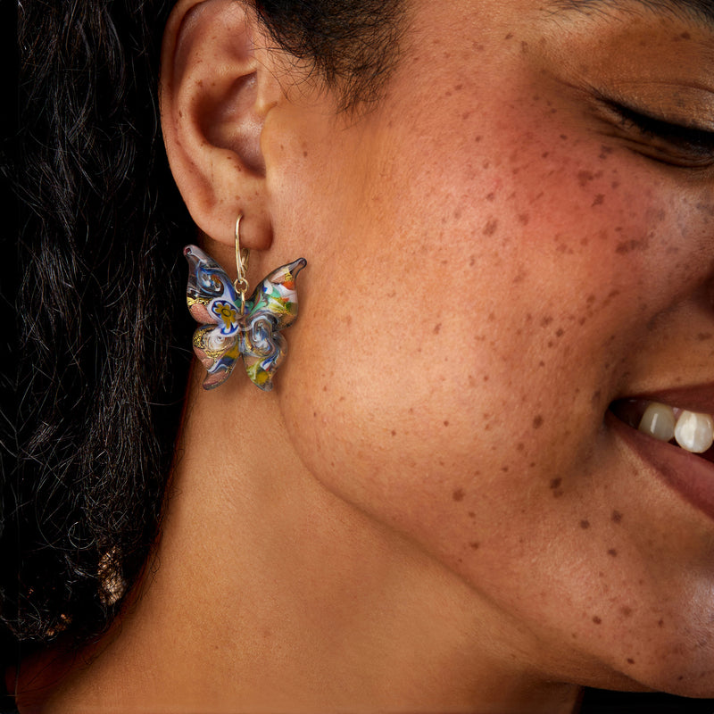 Murano glass butterfly drop earrings on ear with gold leverback hooks, multicolor