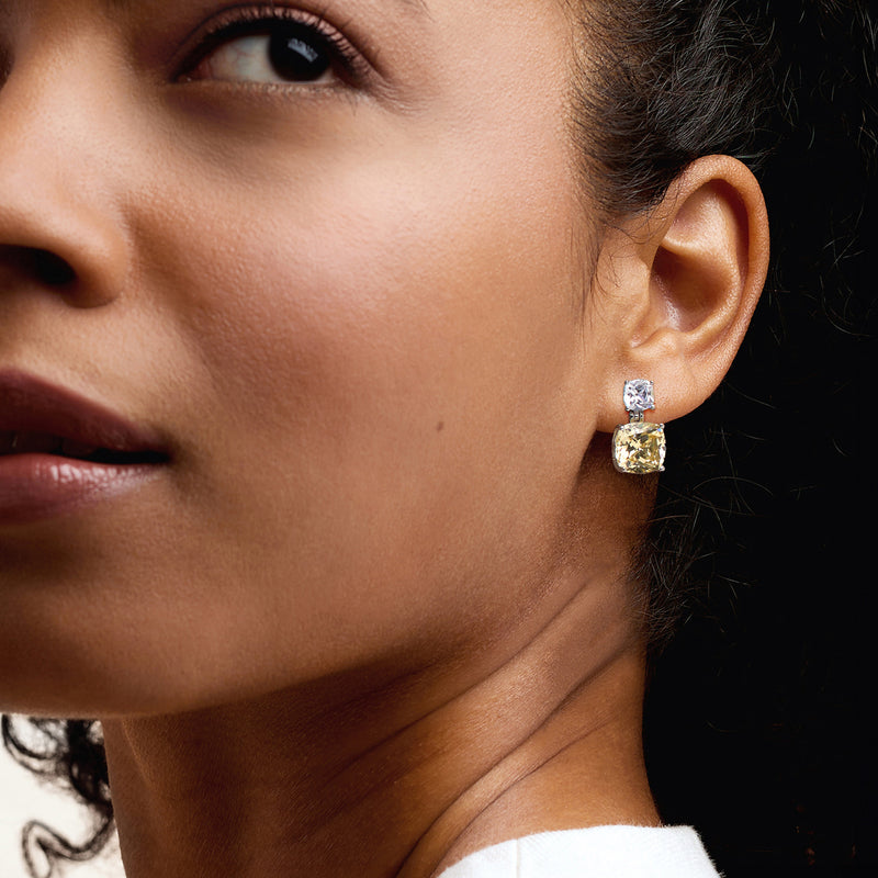 Yellow and white CZ drop earring on ear with sterling silver setting