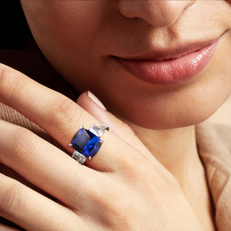 Sterling silver ring on hand, blue center stone with two clear side CZ stones