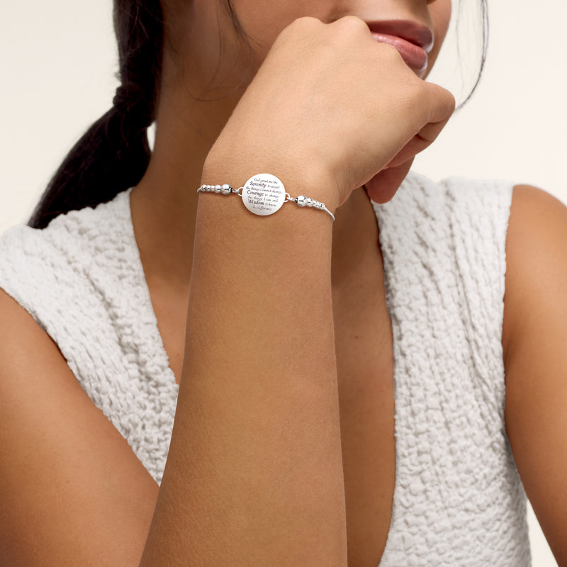Sterling silver bolo bracelet worn on wrist with round Serenity Prayer charm