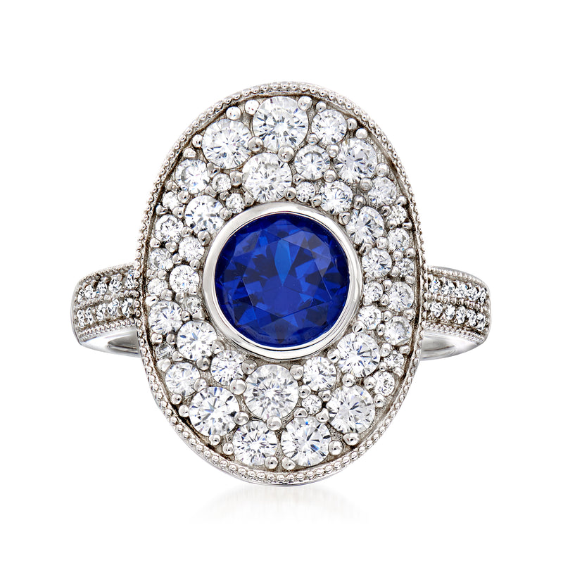 Sterling silver ring with oval blue simulated sapphire center and clear CZ halo