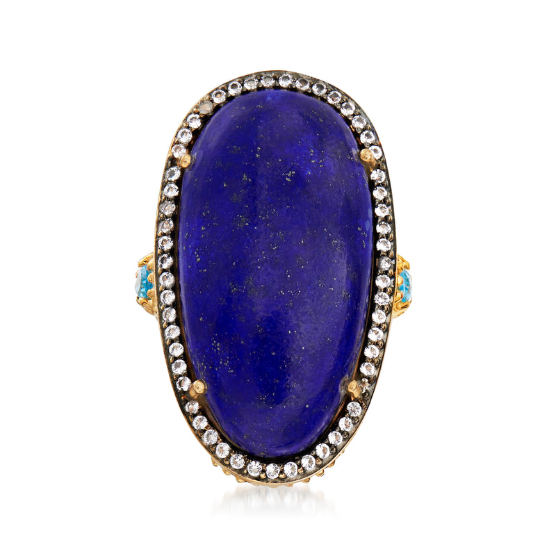 Oval lapis cocktail ring with blue center stone and clear diamond-like halo, gold setting