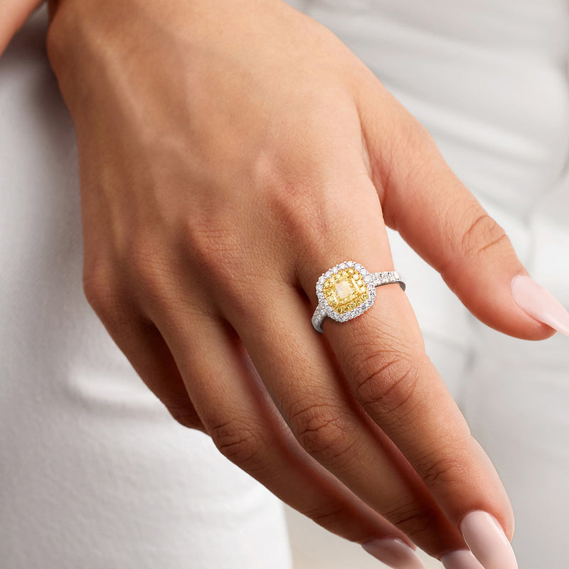 Two-tone gold diamond halo ring on hand; cushion yellow center with white halo