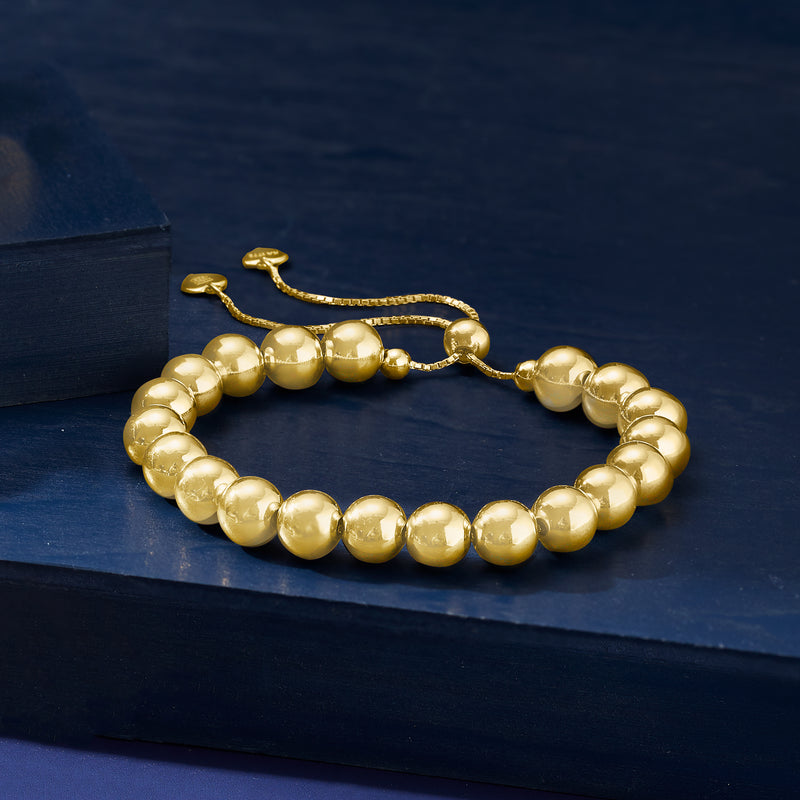 Gold-tone round bead bolo bracelet with adjustable sliding cord and clasp.