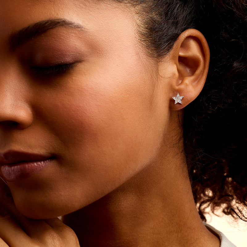 Star diamond stud earrings in sterling silver worn on ear