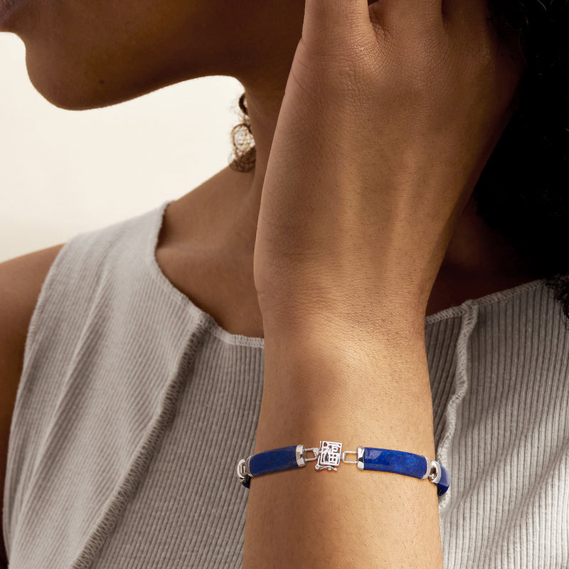 Sterling silver lapis bracelet worn on wrist with blue inlays and square clasp charm