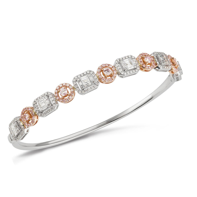 Two-tone gold diamond bangle with alternating round and baguette stones, hinged bracelet