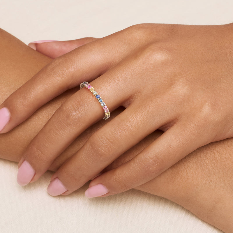 14kt yellow gold multicolored sapphire eternity band on finger