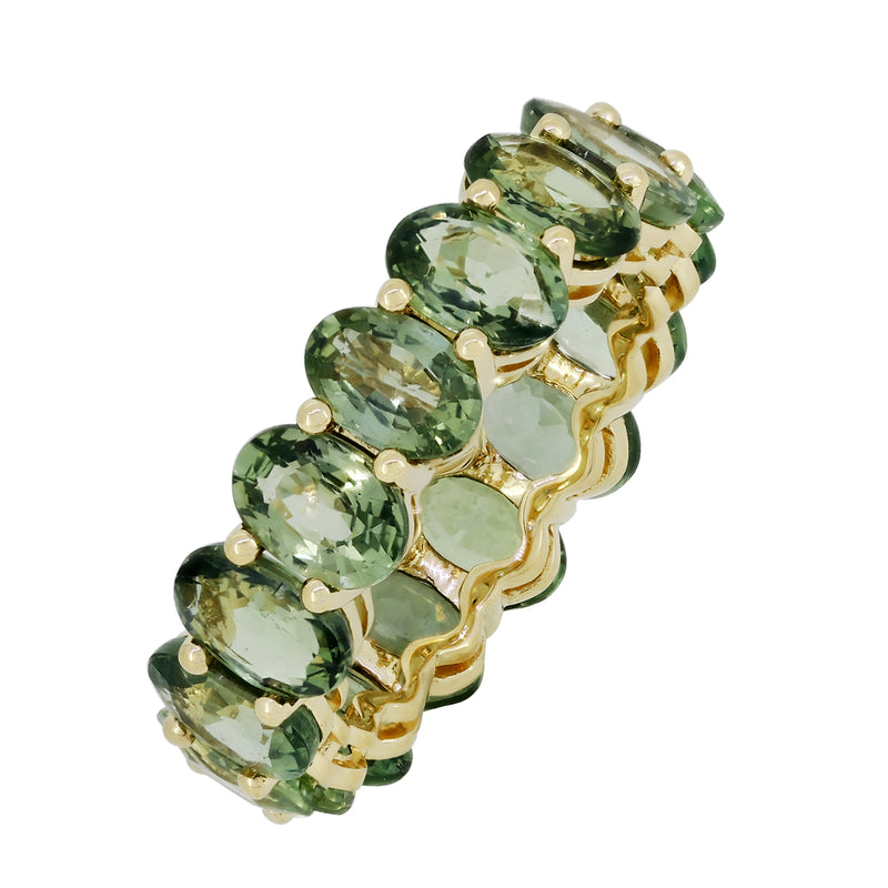 Oval green stone eternity band in 18kt yellow gold, angled view