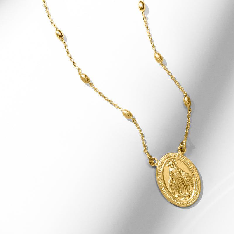 Gold-tone pendant necklace with oval Miraculous Medal charm at lower front