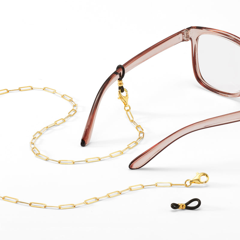 Gold-over-sterling link chain with eyeglass clip and rings, laid across glasses