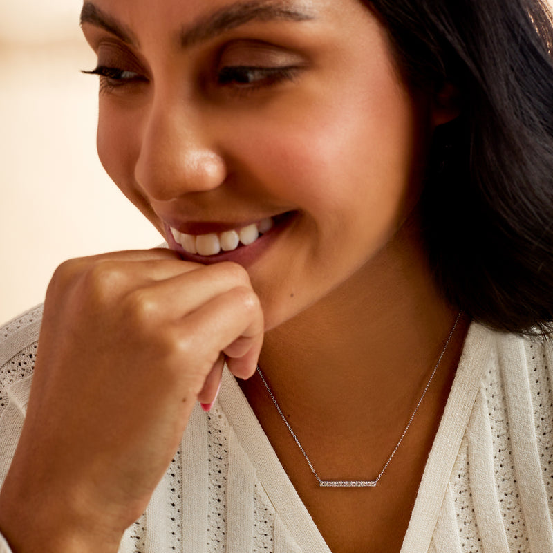 Sterling silver diamond bar necklace worn with thin chain and rectangular pendant