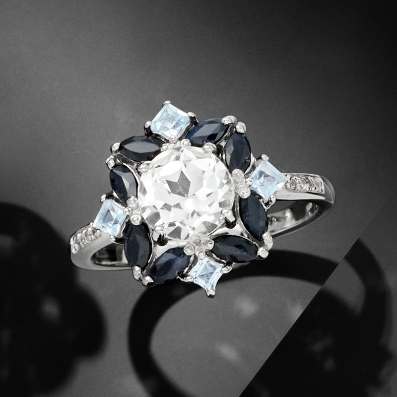 Sterling silver ring with large white center stone, surrounded by navy and light blue gems