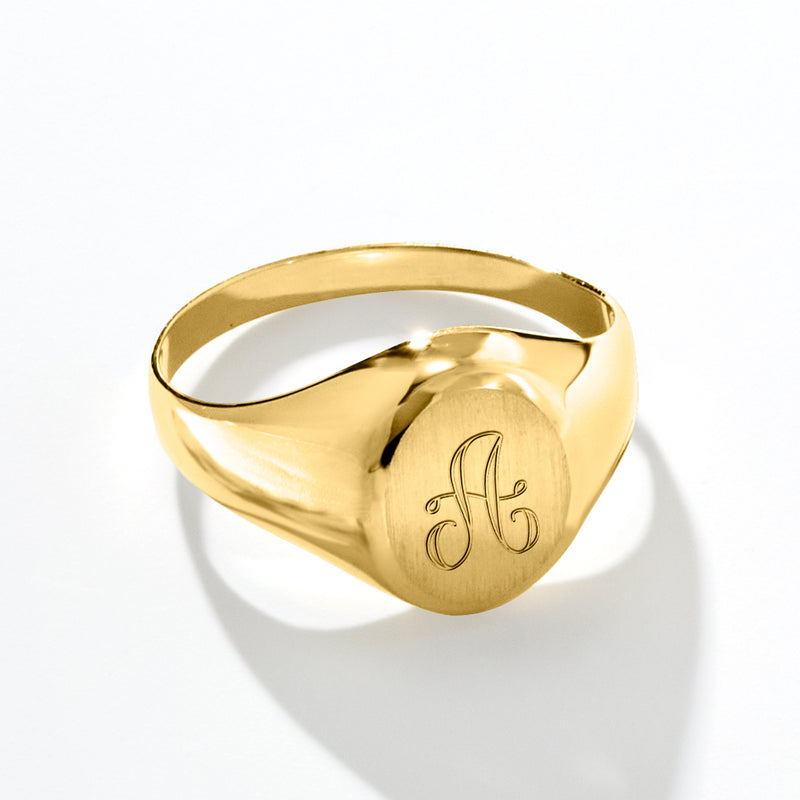 Yellow gold signet ring with engraved monogram visible on top face