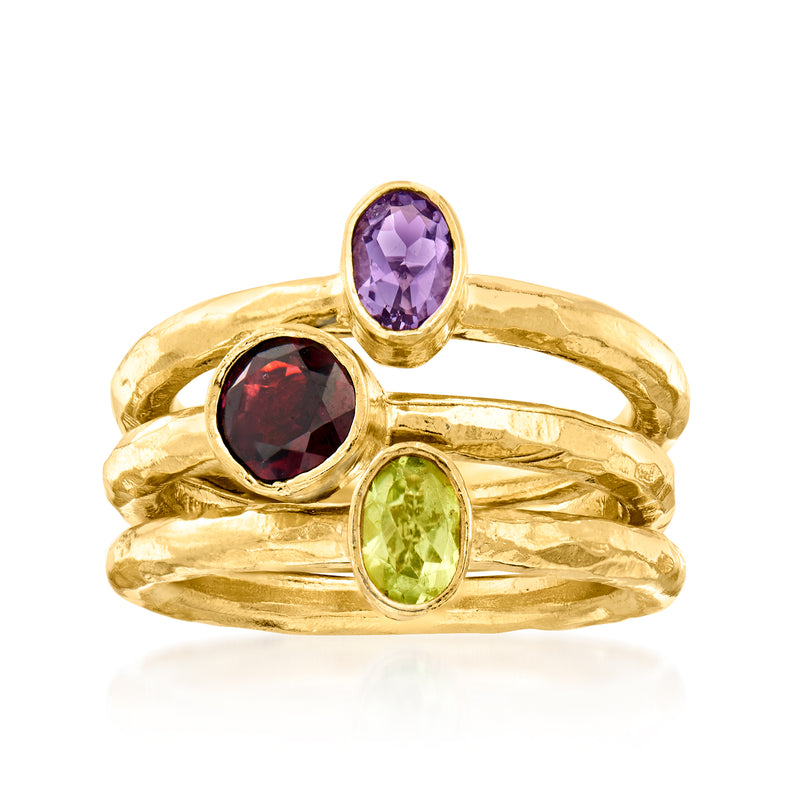 Three gold over sterling rings with oval amethyst, garnet, and peridot gemstones
