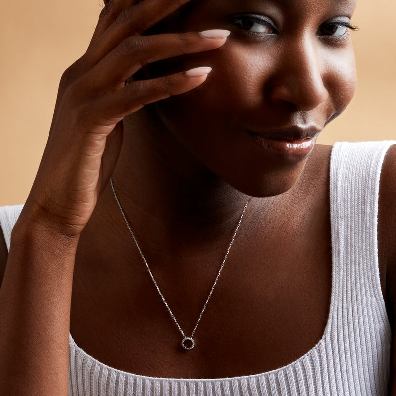 Sterling silver diamond circle pendant necklace worn on collarbone
