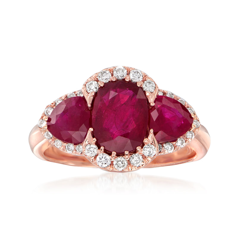 14kt rose gold ring with ruby center, marquise side rubies, and round diamond halo