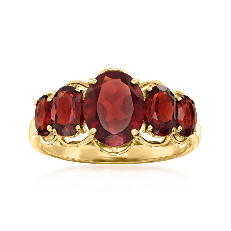 14kt yellow gold garnet ring with oval red center stone and two side stones