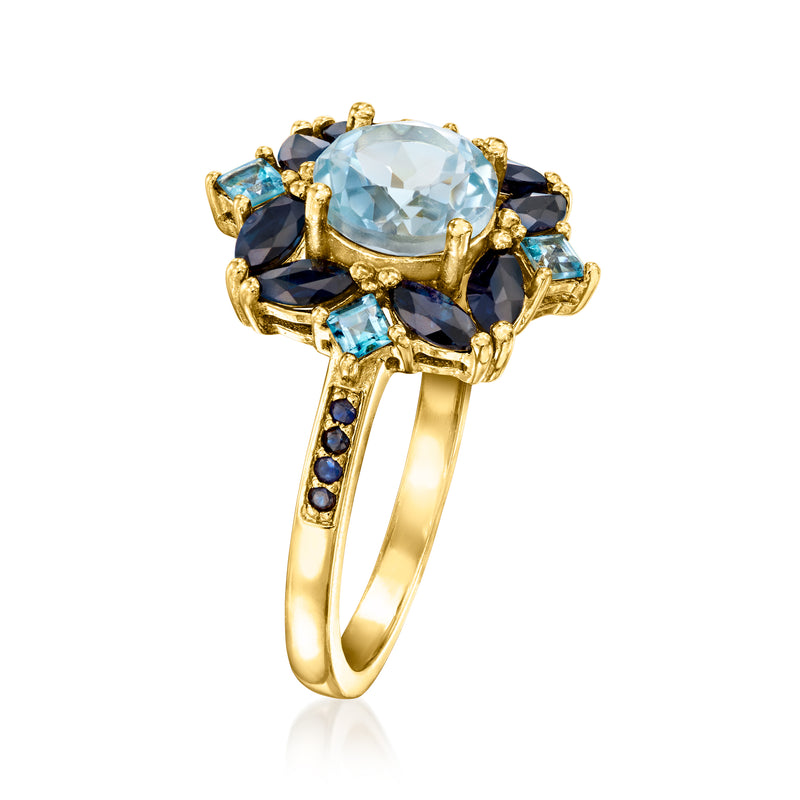 Gold over sterling ring showing round sky-blue centerpiece with navy blue accent stones