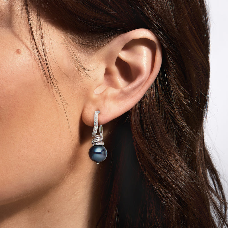 Black pearl drop earrings with diamond accents on ear, sterling silver leverback