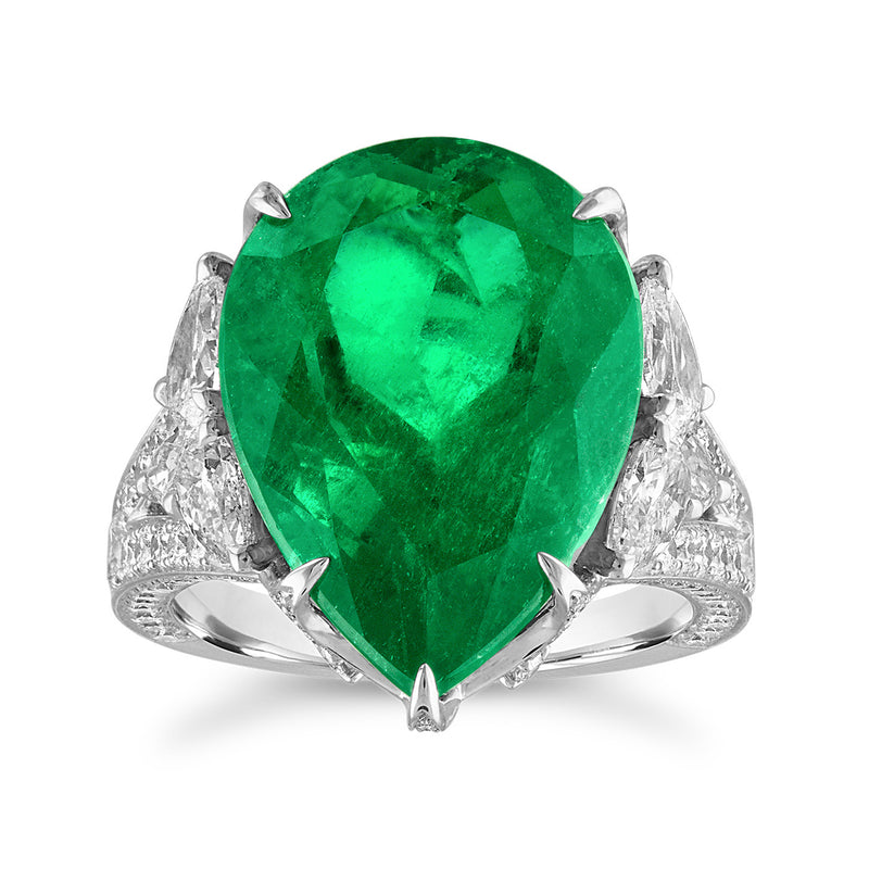 Oval green emerald center with diamond side accents on 18k white gold ring