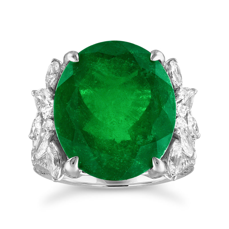 Green emerald center ring with diamond side stones in 18k white gold setting